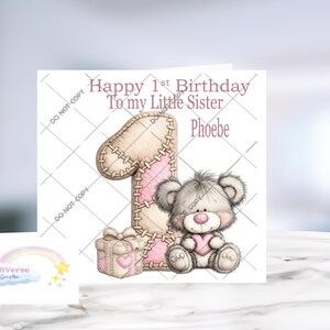 Pu&ograve; includere: Un biglietto d'auguri quadrato con il testo Happy 1st Birthday To my little Sister Phoebe. Il design include un grande numero uno beige con cuciture rosa, una piccola scatola regalo e un orsacchiotto grigio che tiene un cuore rosa.