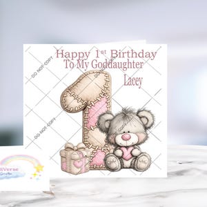 Pu&ograve; includere: Un biglietto d'auguri quadrato con un grande numero uno cucito in beige e rosa, un piccolo pacchetto regalo e un soffice orsacchiotto grigio che tiene in mano un cuore rosa. Il testo recita Happy 1st Birthday To My Goddaughter Lacey.