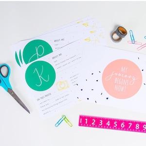 Può includere: Un set di carte stampabili con un cerchio rosa che dice "Il mio viaggio inizia ora!" e un cerchio verde con la lettera "K". Le carte hanno suggerimenti per un bambino da compilare su se stesso, come la sua età, cosa lo rende felice e la sua cosa preferita di una foto.