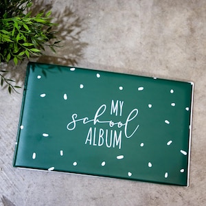 May include: A green photo album with white polka dots and the text "My School Album" in white cursive lettering.