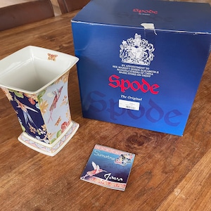 May include: A blue and white porcelain vase with a floral design featuring birds. The vase is in a box with the Spode logo and the text "The Original".