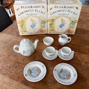 Puede incluir: Un juego de té para niños Peter Rabbit de Wedgwood. El juego incluye una tetera, dos tazas y platillos, una jarra de crema y un azucarero. El juego de té está decorado con ilustraciones de Peter Rabbit.