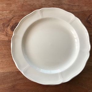 Op de afbeelding: Een wit keramiek dinerbord met een gegolfde rand.