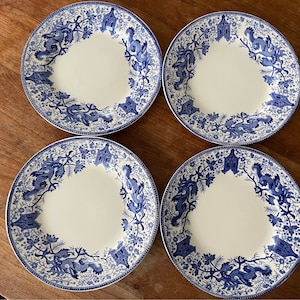 May include: Set of four blue and white porcelain dinner plates with a floral and bird design.