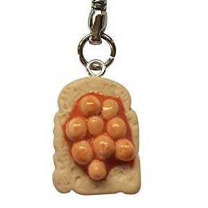 May include: A silver key chain with a springy metal extension and a charm of a slice of toast with baked beans on top.