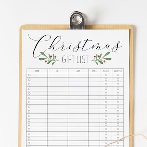 May include: A printable Christmas gift list checklist on a clipboard with a brown wooden frame. The checklist has columns for name, gift, store, price, bought, and wrapped. A brown gift box with white polka dots is wrapped with twine and a sprig of pine with red berries.