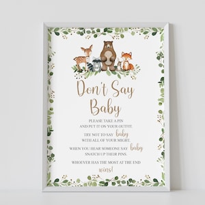 May include: A printable sign with a woodland theme for a baby shower game. The sign says "Don't Say Baby" and includes instructions for a game where guests try not to say the word "baby".