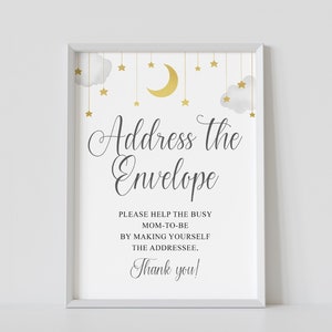 Puede incluir: Un cartel blanco imprimible con una luna creciente dorada y estrellas, con el texto "Address the Envelope" y "Por favor, ayuda a la futura mamá haciendo que te conviertas en el destinatario. ¡Gracias!"