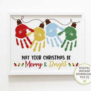May include: A framed print with a white border features colorful handprints shaped like Christmas lights. The handprints are red, yellow, blue, and green. The text reads "May Your Christmas Be Merry & Bright."