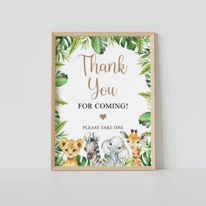 May include: A printable thank you sign with a jungle theme. The sign features a lion, zebra, elephant, and giraffe with green leaves and the text "Thank You for Coming! Please Take One".