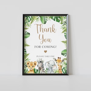 May include: A printable thank you sign with a jungle theme. The sign features a lion, zebra, elephant, and giraffe surrounded by green leaves and the text "Thank You for Coming!" with a heart.