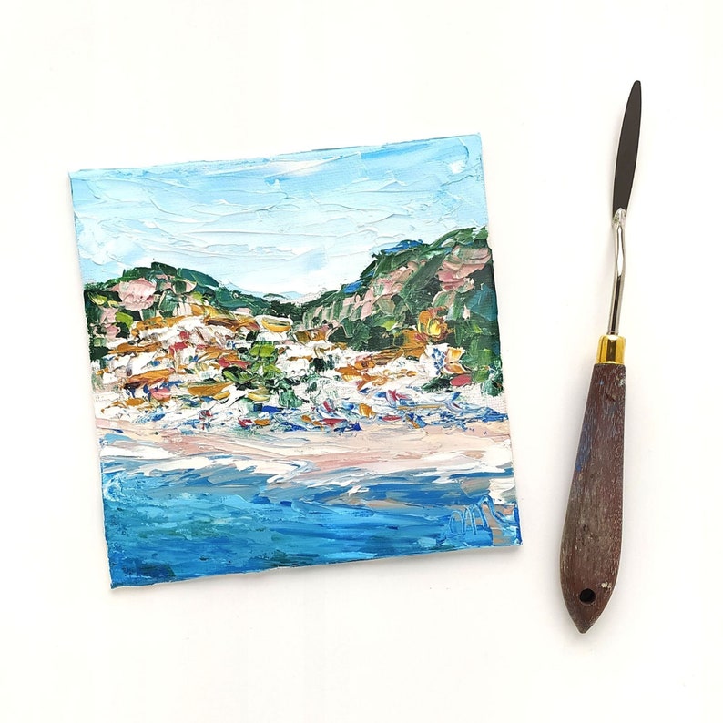May include: A small painting of a seascape with a town on a hillside. The painting is done in a loose, impressionistic style with thick brushstrokes. The colors are bright and vibrant, with blues, greens, and yellows dominating the scene.