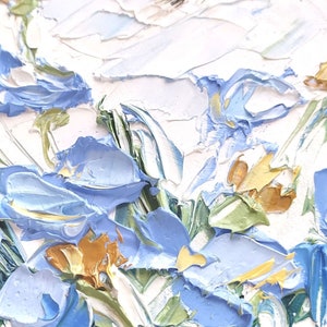 May include: A close-up of a painting depicting a bouquet of blue flowers with yellow centers. The flowers are painted in a thick, textured style, giving the painting a three-dimensional effect.