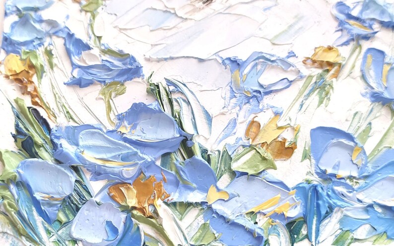 May include: A close-up of a painting depicting a bouquet of blue flowers with yellow centers. The flowers are painted in a thick, textured style, giving the painting a three-dimensional effect.