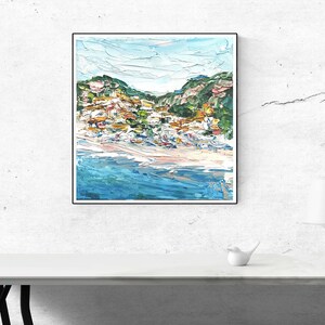 May include: A painting of a coastal town with colorful buildings on a hillside overlooking a blue ocean. The painting is done in a loose, impressionistic style with visible brushstrokes.