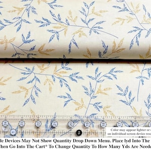 May include: A beige fabric with a repeating pattern of blue and yellow leaves. The fabric is folded in half and a ruler is placed on top of the fabric. The ruler is marked with inches. The text on the fabric reads: "Mobile Devices May Not Show Quantity Drop Down Menu. Place lyd Into The Cart *Then Go Into The Cart* To Change Quantity To How Many Yds Are Needed"