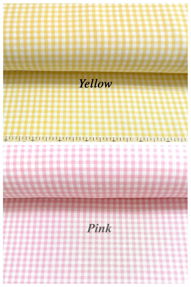 Puede incluir: Dos rollos de tela de cuadros vichy, uno amarillo y otro rosa, cada uno con un patr&oacute;n de cuadros peque&ntilde;os. Una regla es visible a lo largo del borde inferior de la tela amarilla, mostrando marcas en cent&iacute;metros para escala y medida.