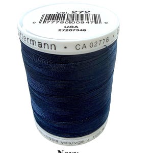 Pode incluir: Um carretel de linha de costura azul-marinho da marca G&uuml;termann. A etiqueta superior branca exibe o texto Col. 272, um c&oacute;digo de barras, USA e 27267348. A lateral apresenta o nome G&uuml;termann e CA 02776. A etiqueta inferior indica 1094 yds/vgs.