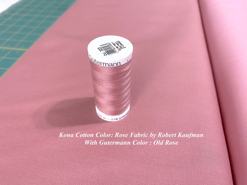 May include: A spool of Gutermann thread in the color Old Rose, next to a piece of Kona Cotton fabric in the color Rose. The text on the spool reads "Gutermann 21-2743 200 m - 274 yards".