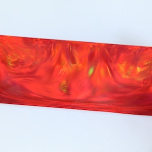 May include: A red, orange, and yellow marbled resin blank with a swirling pattern. The blank is translucent and has a glossy finish.