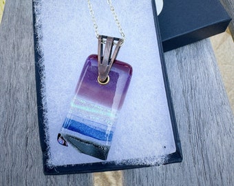 Glass fused pendant custom made by Jeanne. Colors sparkling purple, blue, grey and dichroic pink and shimmering green.
