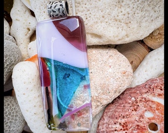 Glass fused pendant custom made by Jeanne. Colors sparkling pink, purple and shimmering blue with many accents.