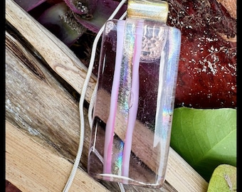 Glass pendant is a rectangular shape. Colors are transparent dichroic clear  with light pink stripes. Shimmering with light.