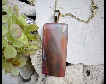Glass pendant is a medley of colors  transparent dichroic peaches and pinks shimmering with light.