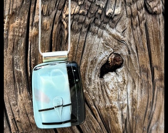 Hand made glass pendant. Fused by artist. Ice blue and balck with light pink accents and aesthetic bubble.