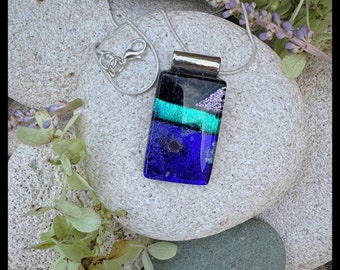 Hand made glass pendant. Fused by artist. Bright royal blue with a streak of turquoise dichroic sparkle and balck.