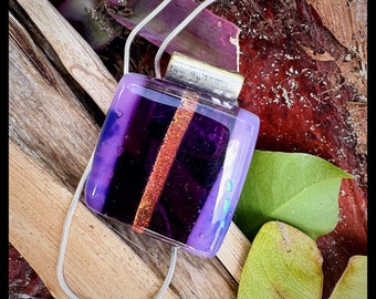 Glass fused pendant custom made by Jeanne. Colors are a variety of sparkling deep purples with copper toned dichroic stripe.