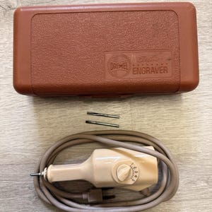 May include: A white ceramic mug with a black handle and the text "But First, Coffee" in a handwritten style. The mug is on a white surface. The mug is approximately 4 inches tall.