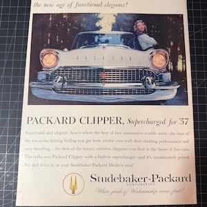 May include: A vintage advert for the Packard Clipper, supercharged for '57. The image shows a classic car with a woman leaning against it. The ad includes the Studebaker-Packard logo and text promoting the car's features and elegance.