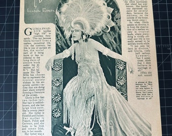 May include: A vintage magazine page featuring a black and white photo of Gloria Swanson. She is wearing a feathered headdress and a long, flowing gown. The headline reads "Gloria Swanson Talks on Divorce."