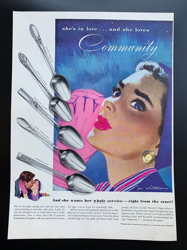 May include: A vintage advertisement for Community silverplate featuring a woman with blue eyes and red lips. The text reads "she's in love... and she loves Community" and "And she wants her whole service-right from the start!" The ad shows a variety of silver spoons with the names "White Orchid", "Evening Star", "Morning Star", "Lady Hamilton", and "Coronation" printed on them.