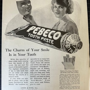 May include: A vintage black and white advertisement for Pebeco Tooth Paste. The image shows a woman and a tube of toothpaste. The text on the tube reads "PEBECO TOOTH PASTE". The ad includes text about the product's benefits and a mask.