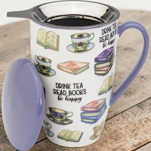 Puede incluir: Una taza de té de cerámica blanca con asa y tapa de color lavanda, que incluye un infusor de acero inoxidable. La taza está decorada con ilustraciones de libros abiertos, libros apilados y tazas de té florales, con el texto DRINK TEA READ BOOKS be happy.