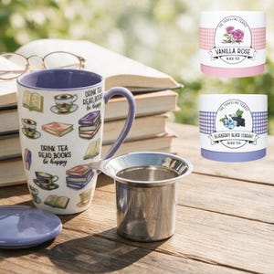 May include: A white ceramic mug with a purple interior and handle, featuring illustrations of books and teacups with the text "DRINK TEA READ BOOKS be happy". Includes a stainless steel tea infuser, a purple lid, and two tea tins labeled "VANILLA ROSE" and "BLUEBERRY BLACK CURRANT".