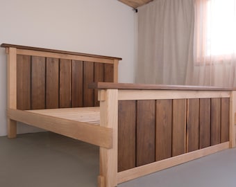 Struttura letto in legno massello di quercia realizzata a mano, con testiera e pediera in stile artigianale.