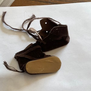 Brown Swede type doll boots tie up the front. 2  1 /4 inch sole  1 inch across