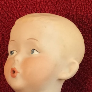 Whistling Jim by German Gebruder Heubach, reproduction made of 1910 doll.  Porcelain bisque, 12 inch, molded hair and whistling mouth.