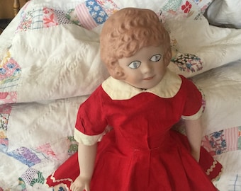 Used Little Orphan Annie doll.  She is porcelain bisque with painted face, legs, and arms.  She has a cloth body.  13 inches tall.