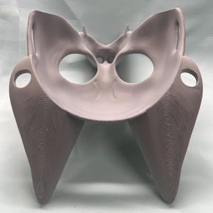 May include: A light gray, 3D-printed anatomical model of a pelvis. The model features a detailed structure with rounded openings and textured surfaces, showcasing the bone structure. The model is designed for educational or medical purposes.