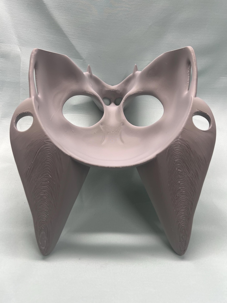 May include: A light gray, 3D-printed anatomical model of a pelvis. The model features a detailed structure with rounded openings and textured surfaces, showcasing the bone structure. The model is designed for educational or medical purposes.