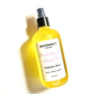 May include: A clear plastic bottle filled with yellow body oil, featuring a black pump dispenser. The white label reads RECONNECT SKINCARE, Floral Sensual Body Oil, Delight Your Senses, NOURISH + HYDRATE + ENCHANT, and 8 FL OZ / 236 ML.