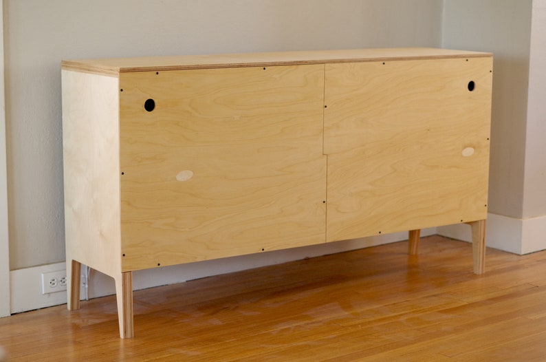 Back view of a modern scandinavian sideboard on a hardwood floor.