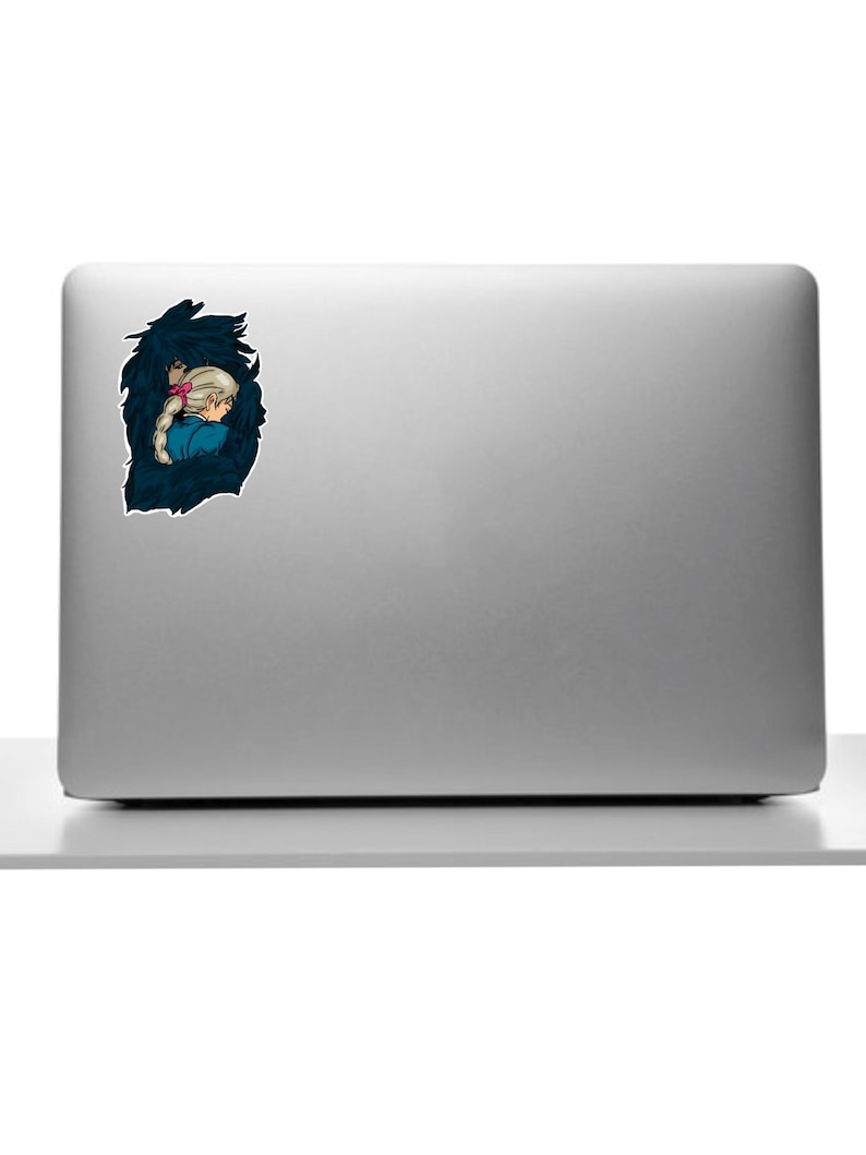 May include: A sticker depicting a cartoon illustration of a person with blonde hair and a pink bow, set against a dark blue, textured background. The person is wearing a blue top. The sticker is on a silver laptop.