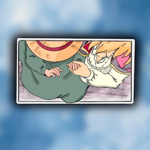 May include: A sticker with an anime-style illustration of two figures holding hands. One figure wears a straw hat and green clothing, the other has blonde hair and a white outfit. The background is a light blue sky.