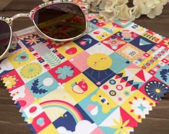 May include: A colorful microfiber cleaning cloth with a patchwork design featuring various geometric shapes, flowers, and other patterns. The cloth is yellow, red, blue, green, and white.