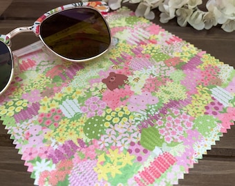 May include: A floral patterned microfiber cleaning cloth with a brown bear design. The cloth is pink, green, and yellow with a variety of flowers.